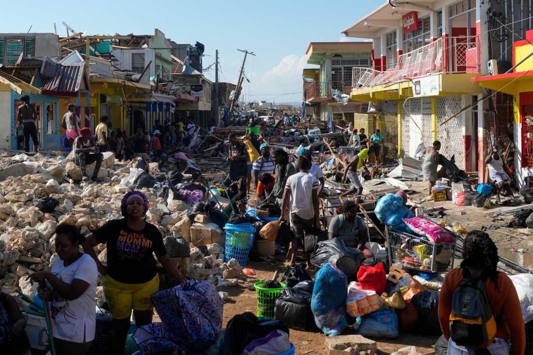 Residents gather amid debris in the aftermath of Hurricane Melissa on a street in Jamaica in October 2025.