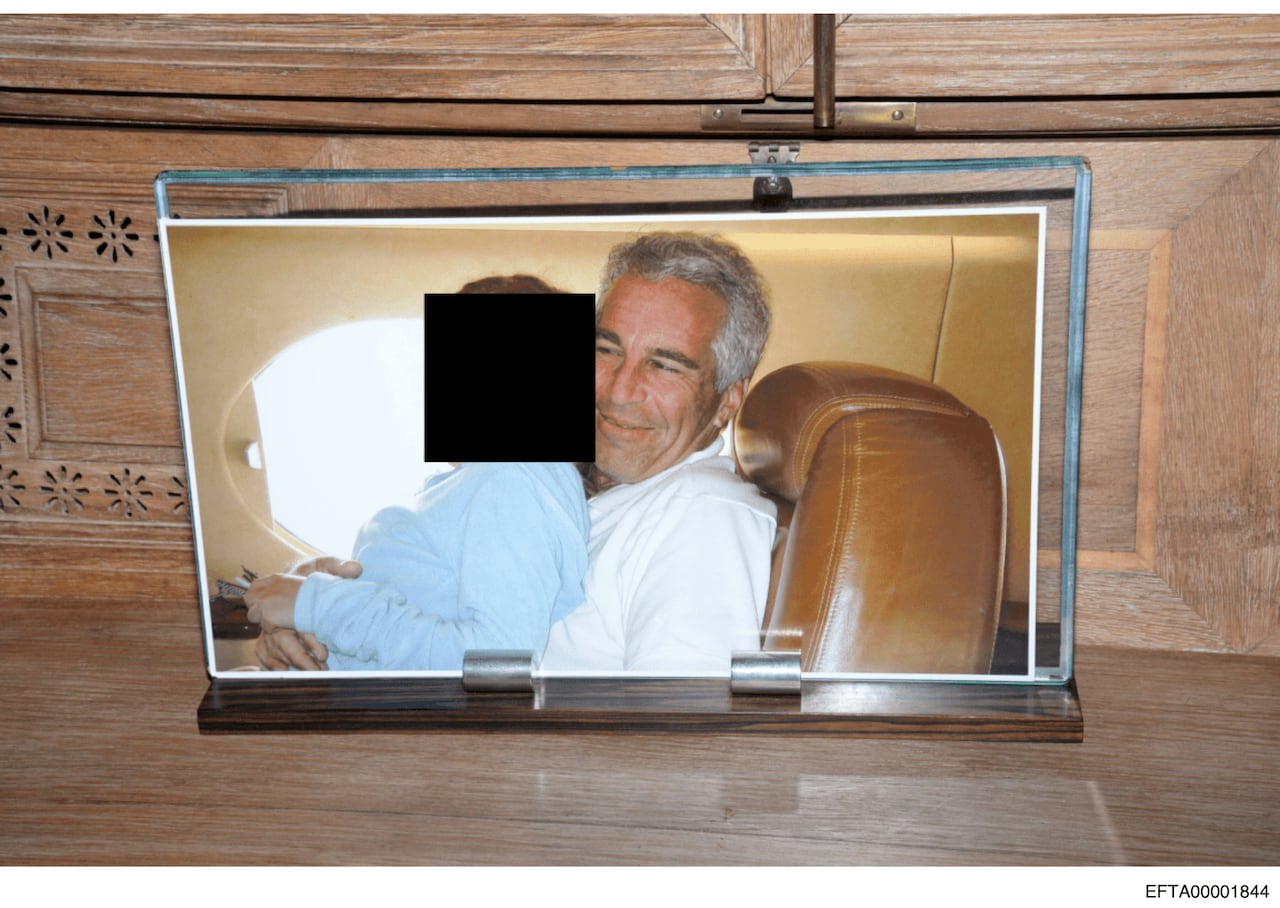 This redacted photo released by the U.S. Department of Justice shows a framed photograph of Jeffrey Epstein with a person on his lap, documented on Aug. 12, 2019, during a search of his home on Little St. James island in the U.S. Virgin Islands. 
