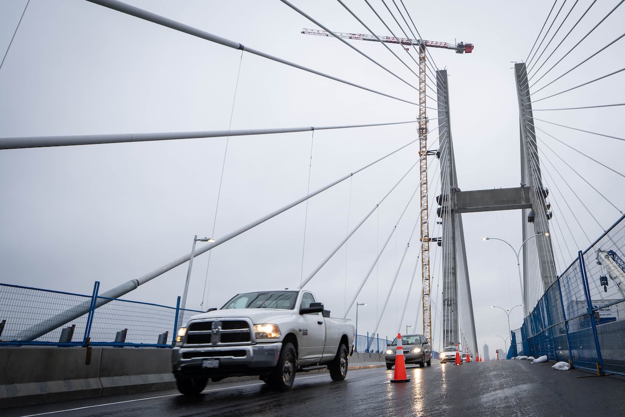 Vehicles pass by a lane in a bridge on a rainy day.