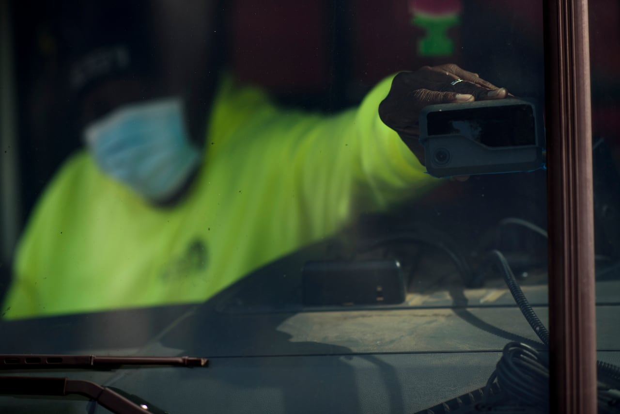 A hand inside a vehicle adjusting a square sensor