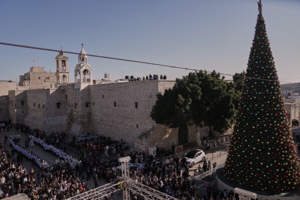 Catholic clergy walk in procession next to the Church of the Nativity, traditionally believed to be the birthplace of Jesus, on Christmas Eve, in the West Bank city of Bethlehem, Wednesday, Dec. 24, 2025. (AP Photo/Mahmoud Illean)