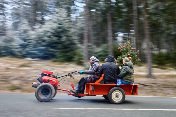 People drive up to the top of the Feldberg mountain near Frankfurt, Germany, to join the traditional Christmas Eve meeting of tractor and motorbike drivers early Wednesday, Dec. 24, 2025. (AP Photo/Michael Probst)