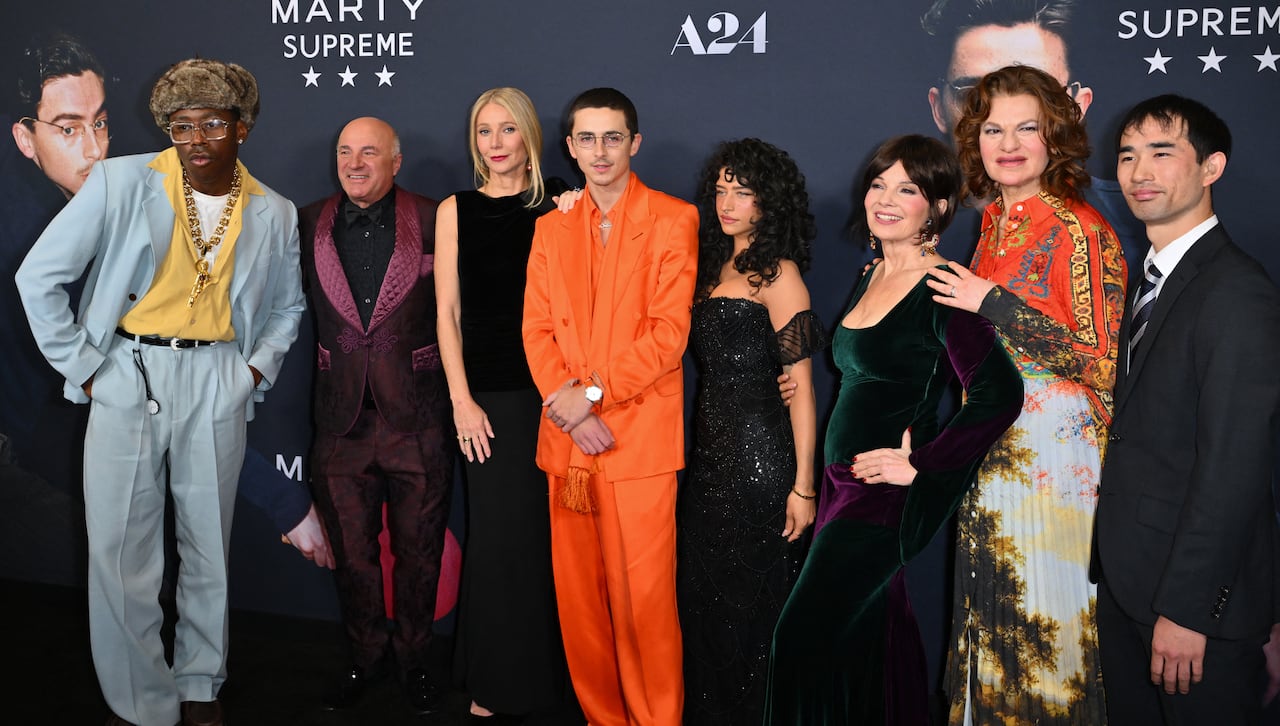 The cast of actors and actresses from the movie Marty Supreme pose on a red carpet at a film screening.