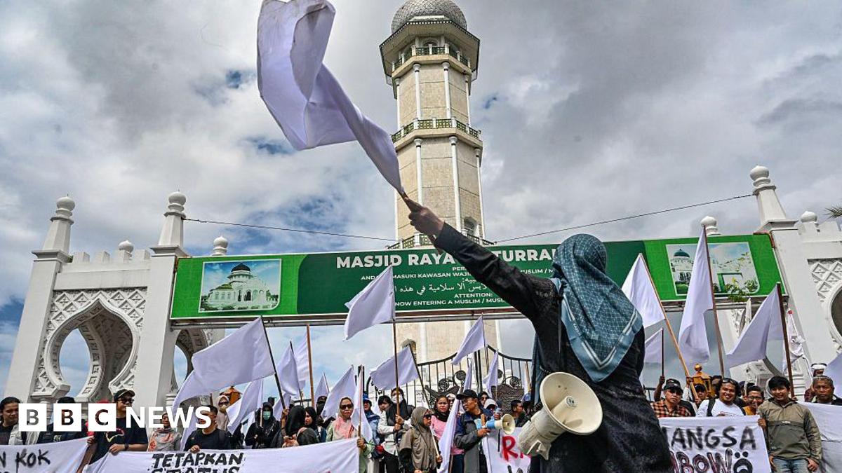 Activists protest with white flags in front of a mosque in Banda Aceh to demand that the Indonesian government opens the door to foreign aid