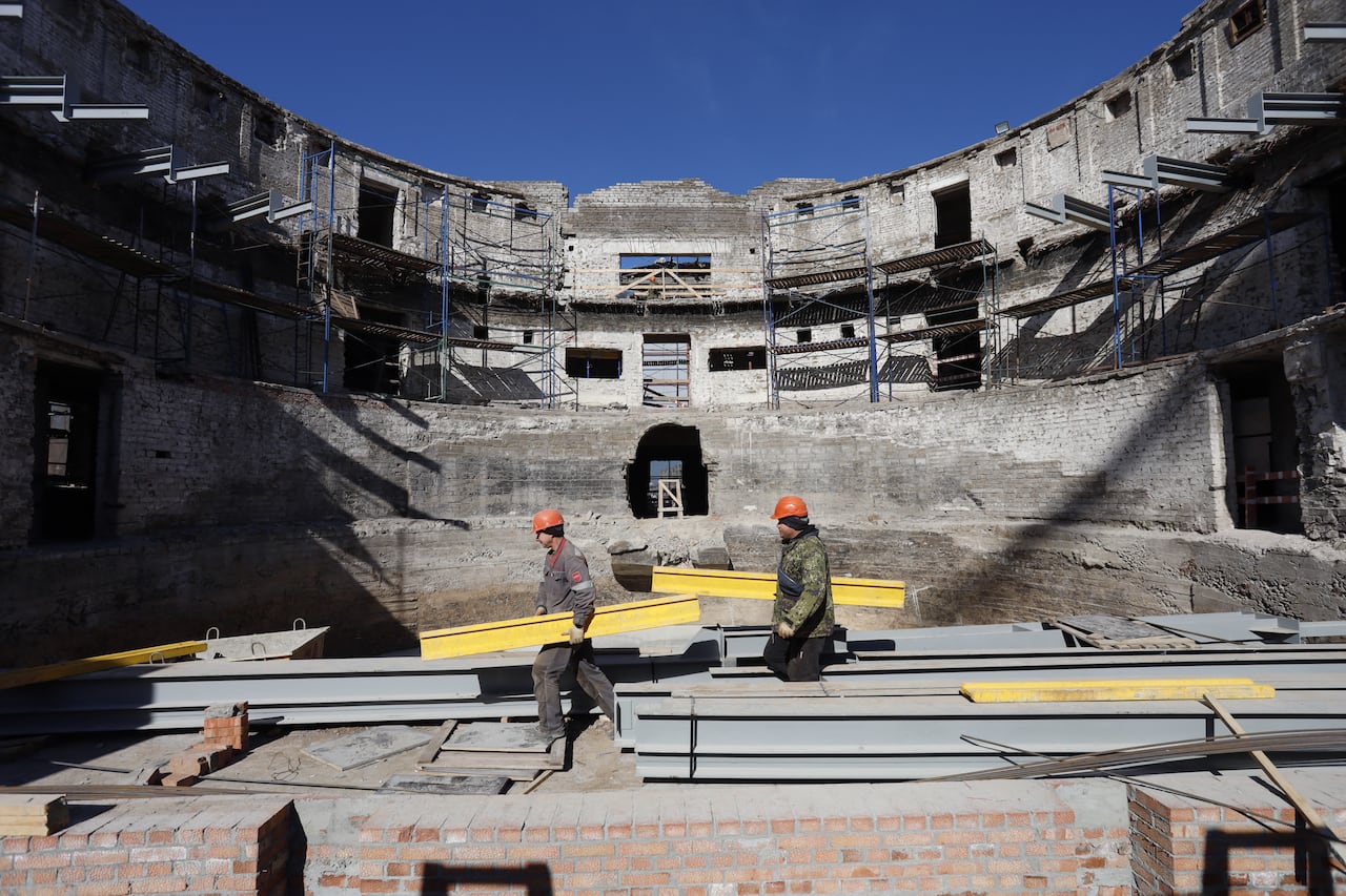 Construction workers rebuild the Mariupol Drama Theatre in Mariupol, Russian-controlled Ukraine, on April 4, 2024. 