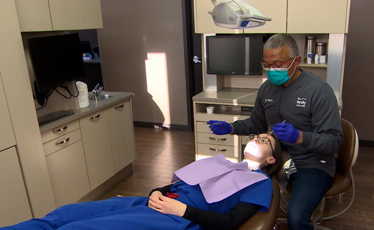 A dentist does a dental exam of patient in an office