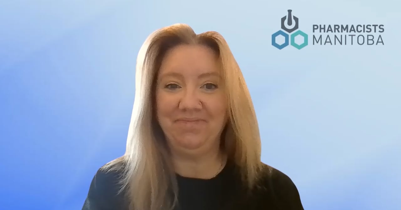 Woman with long blonde hair wears a black sweater infront of a blue background