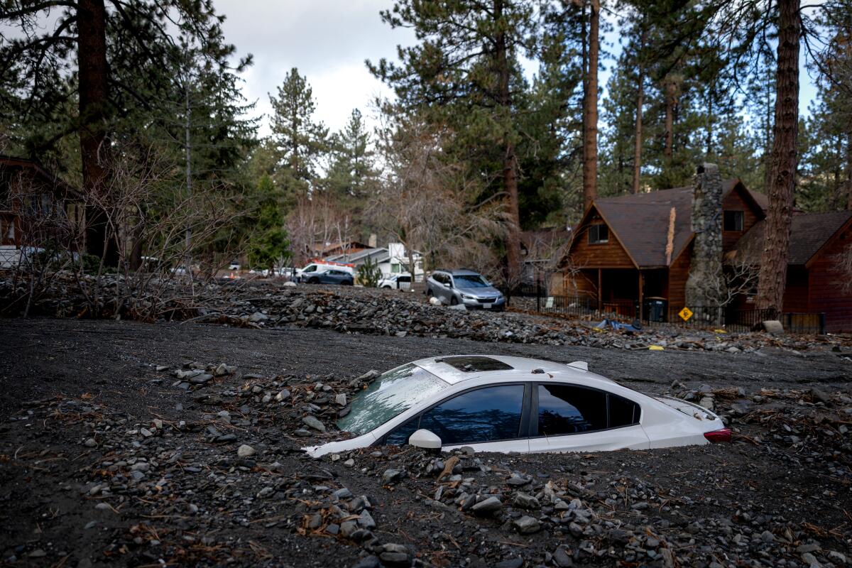 Debris from storm damage covers a car in Wrightwood.