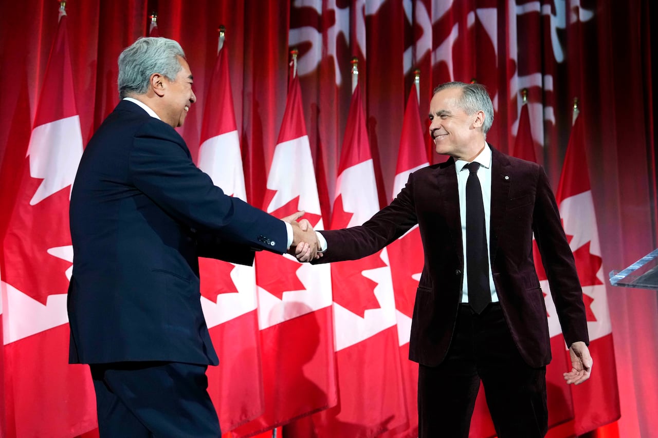 Prime Minister Mark Carney shakes hands with Michael Ma