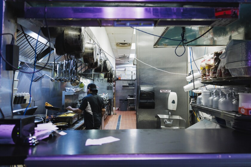 A cook flips a dish while preparing an order at Mariscos La Sirena in suburban Crestwood.
