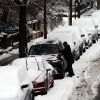 A man cleans off his car of snow in Brooklyn after an overnight storm on Dec. 27, 2025 in New York City.