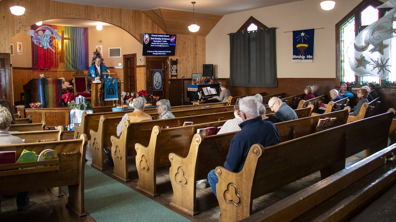 A minister speaks at the pulpit.