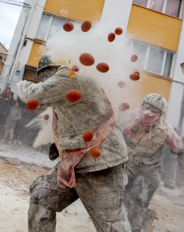 Revellers take part in the Els Enfarinats festival, a battle using flour, eggs and firecrackers, in the town of Ibi near Alicante, Spain, Sunday Dec. 28, 2025. (AP Photo/Alberto Saiz)