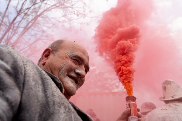 A reveller takes part in the Els Enfarinats festival, a battle using flour, eggs and firecrackers, in the town of Ibi near Alicante, Spain, Sunday Dec. 28, 2025. (AP Photo/Alberto Saiz)