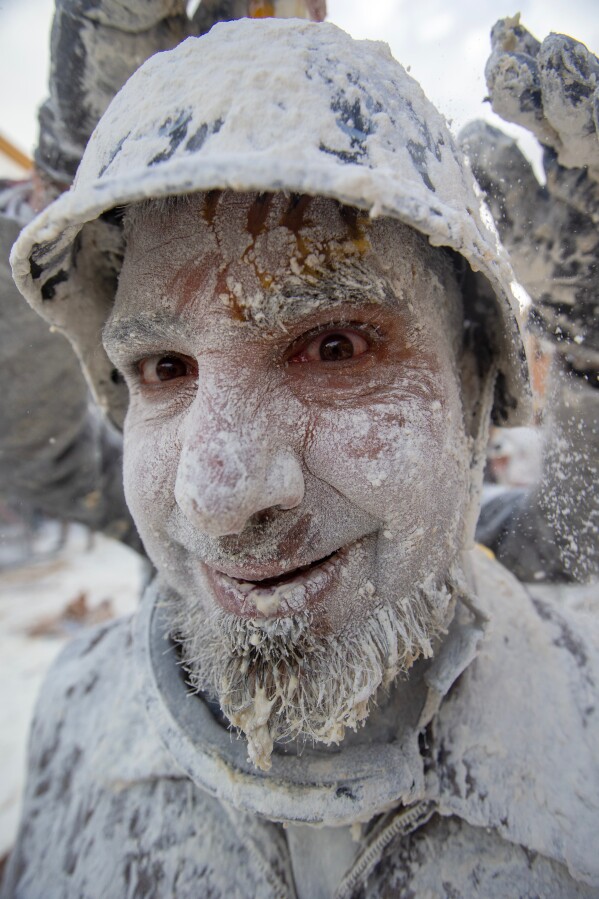 A reveller takes part in the Els Enfarinats festival, a battle using flour, eggs and firecrackers, in the town of Ibi near Alicante, Spain, Sunday Dec. 28, 2025. (AP Photo/Alberto Saiz)