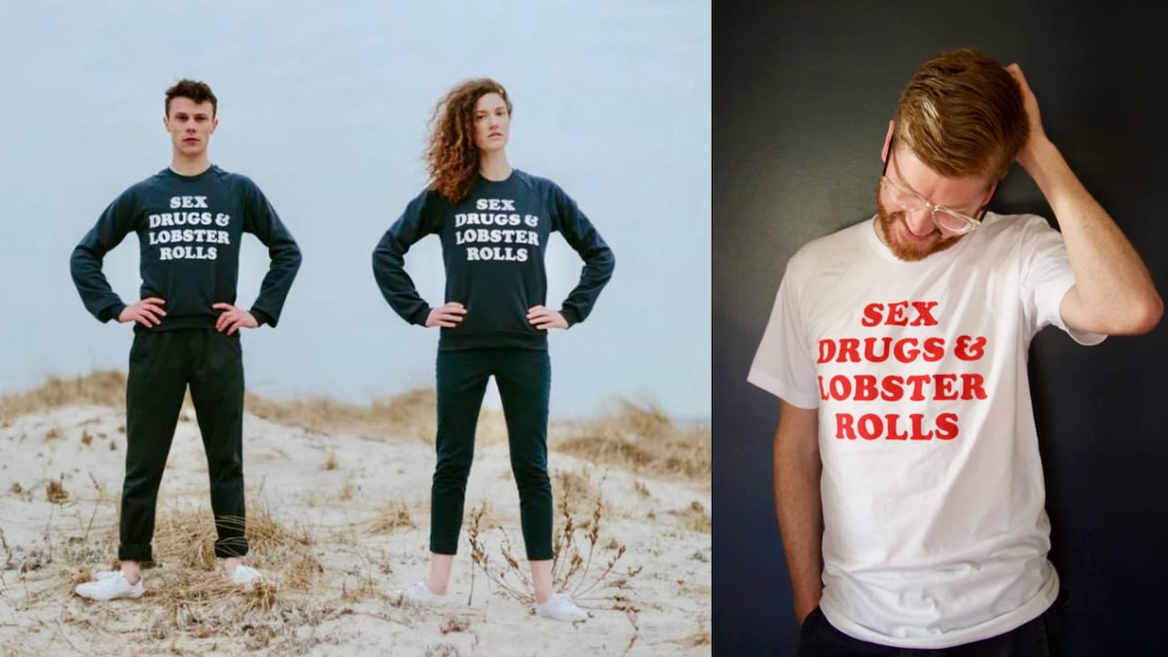 Two people stand on a beach wearing all black.