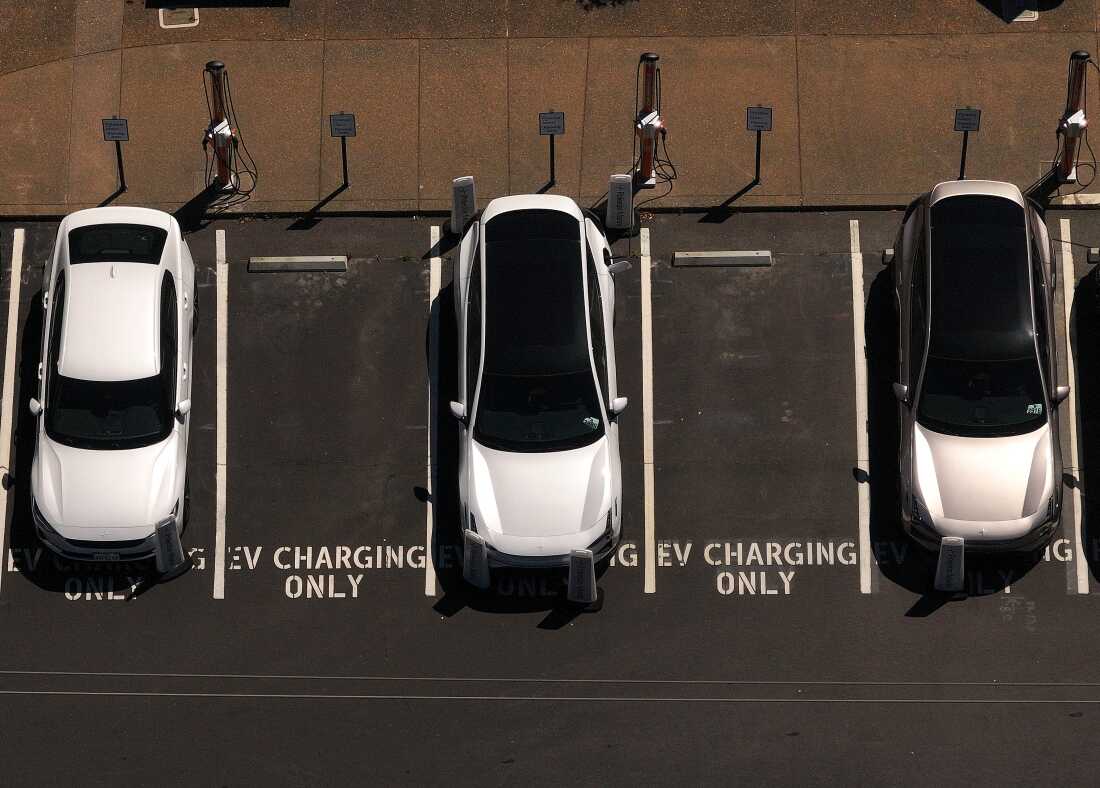 Electric cars sit parked at a charging station in Corte Madera, Calif., in May 2025.