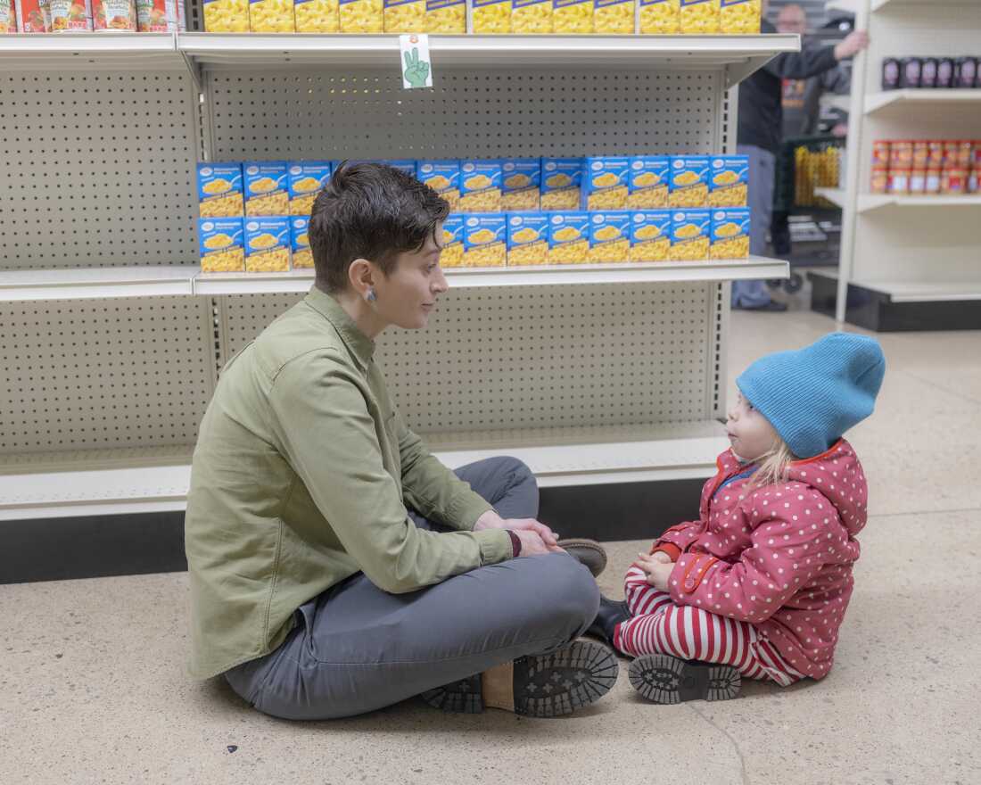 Kelly Hatas, executive director of Hocking Athens Perry Community Action, talks with Amyrose McManaway, 3, of Haydenville, Ohio, while her parents grocery shop at The Market at Hocking Drive on Dec. 9.