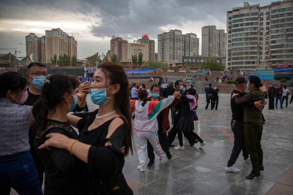 People dance to music at a public square in Aksu in western China's Xinjiang Uyghur Autonomous Region, as seen during a government organized trip for foreign journalists, April 20, 2021. (AP Photo/Mark Schiefelbein, File)