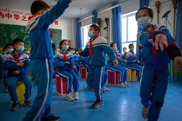 Schoolchildren dance during a music class at a primary school in Awati Township in Kashgar in western China's Xinjiang Uyghur Autonomous Region, as seen during a government organized trip for foreign journalists, April 19, 2021. (AP Photo/Mark Schiefelbein, File)