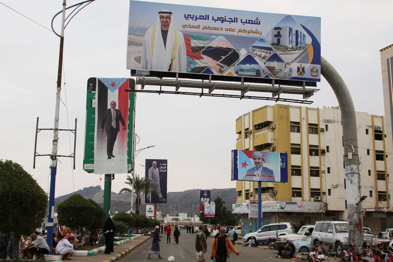 Billboards with images of a man are plastered around a city.
