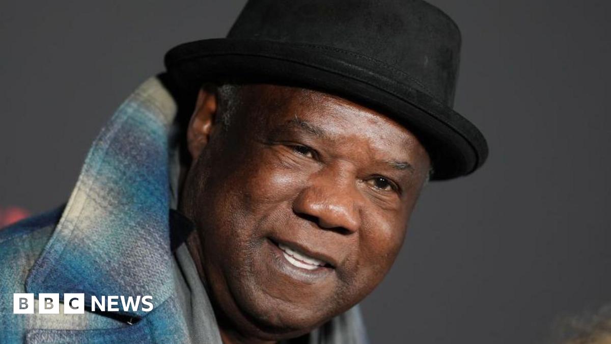 Whitlock, wearing a black hat and a blue flannel jacket