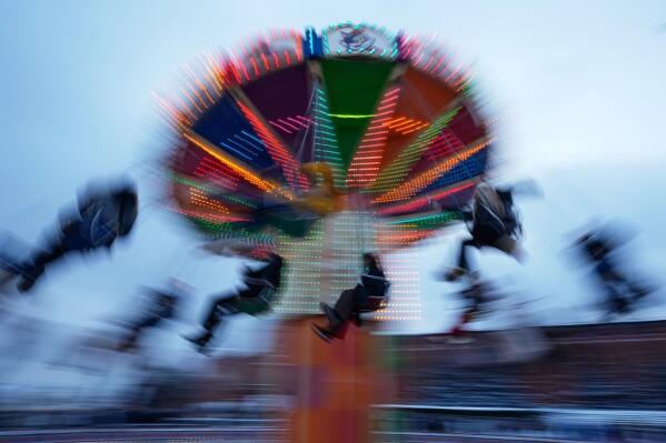 People ride a chair carousel at the Christmas fair on the Red Square on New Year's Eve in Moscow, Russia, Wednesday, Dec. 31, 2025. (AP Photo/Pavel Bednyakov)