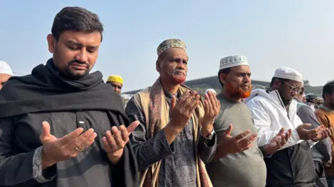 BBC Bangla Four men hold out their hands in prayer at Khaledia Zia's funeral