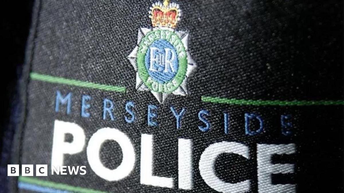 A close-up of a embroidered Merseyside Police badge on black material.