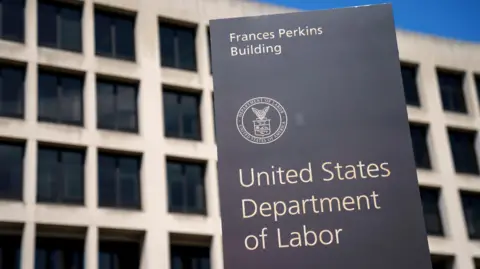 EPA/Shutterstock A sign reading United States Department of Labor stands in front of a cement building.