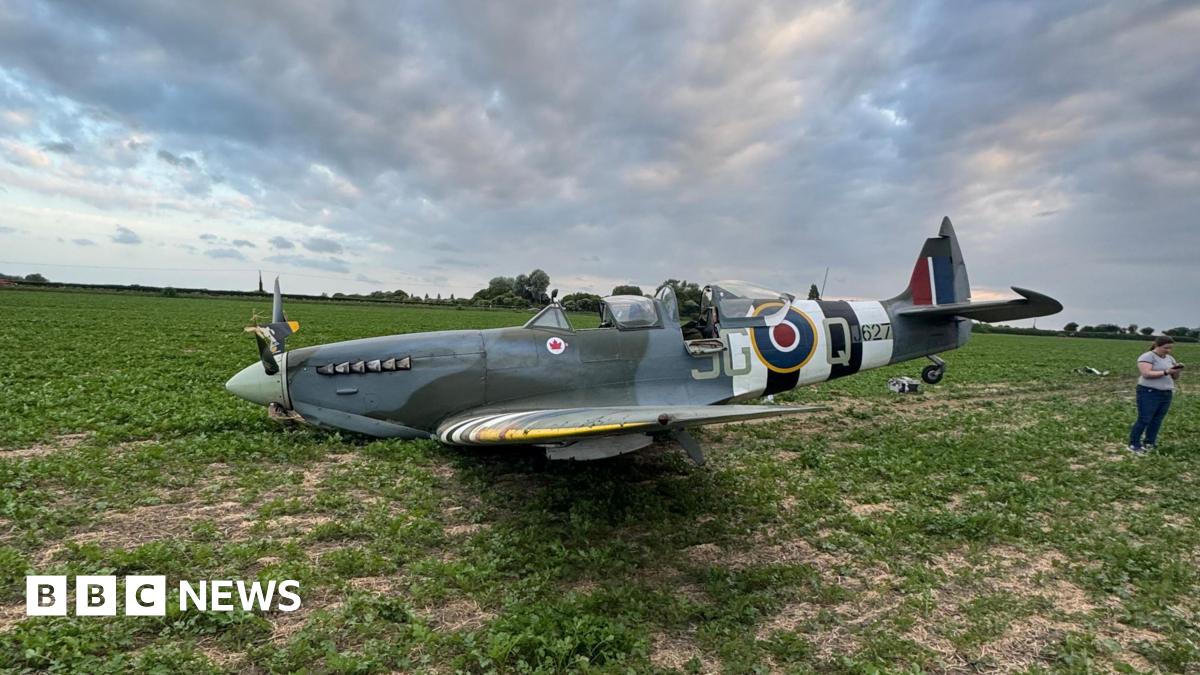 A Spitfire resting on its underside in a farm