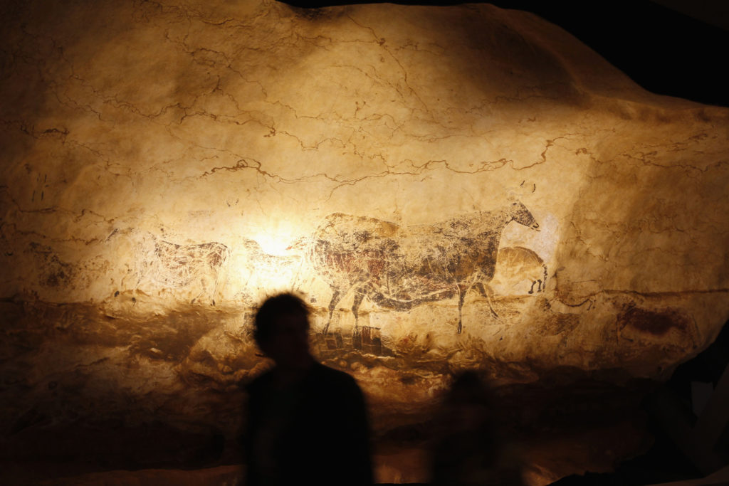 Man looks at a reproduction of the Lascaux caves paintings at the Cap Science's exhibition hall in Bordeaux