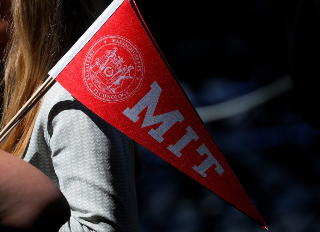 An audience member carries a school pennant before Commencement Exercises at MIT in Cambridge