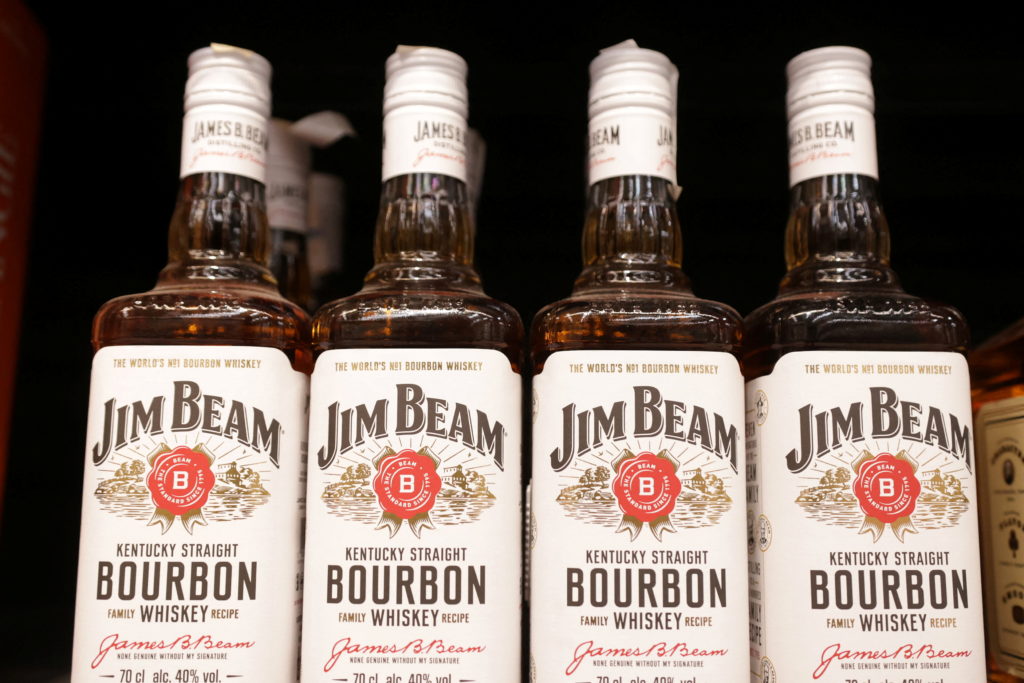 Bottles of Jim Beam are displayed on a shelf in a supermarket