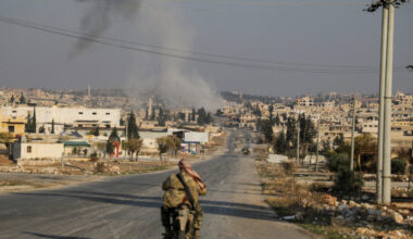 Smoke rises as a member of the rebels led by the Islamist militant group Hayat Tahrir al-Sham drives on a motorbike in al-...
