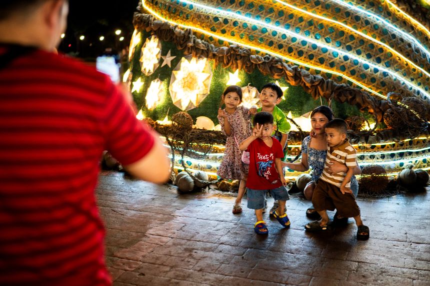 People take pictures in front of a Christmas tree as they celebrate Christmas at the Rizal Park in Manila, onDecember 25, 2024.
