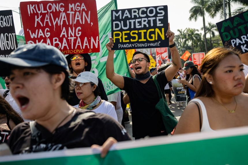 Filipinos shout and raise placards during an anti-corruption protest over widespread graft allegations linked to government infrastructure projects, in Manila, Philippines, on November 30, 2025.