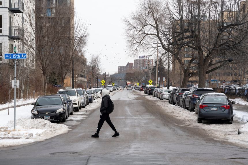 A man walks through the Cedar-Riverside neighborhood, a hub for Somali American residents, amid reports of a planned federal operation targeting Somali immigrants, in Minneapolis, Minnesota, on December 2, 2025.