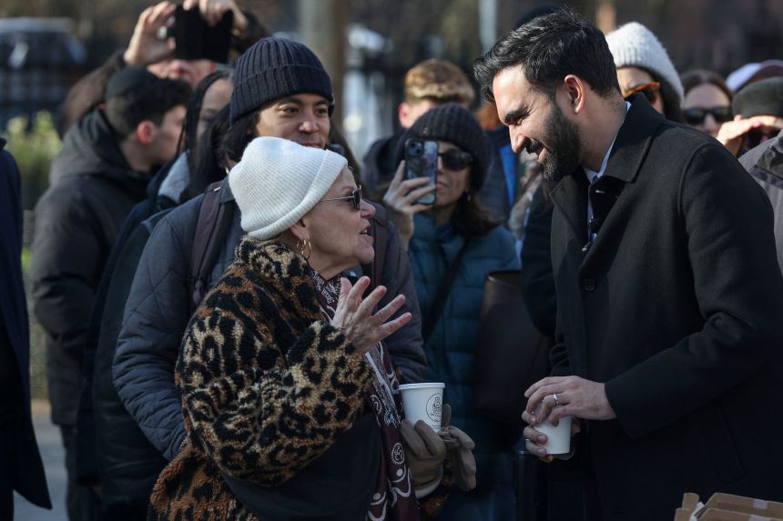 New York City Mayor-elect Zohran Mamdani speaks with a woman as he hands out hot cocoa to people at Stuyvesant Square Park on Thursday, December 4.