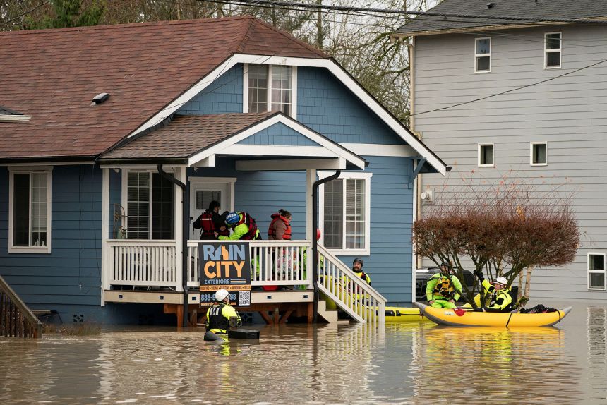 Rescue personnel evacuate Ivan and Fabiola Alvarez, who were stranded in their home in Snohomish, Washington, on December 11.