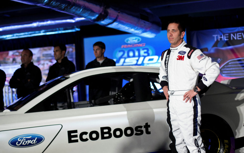 FILE PHOTO: Driver Biffle poses for photographs in front of the new 2013 Ford stock car after an announcement during the N...