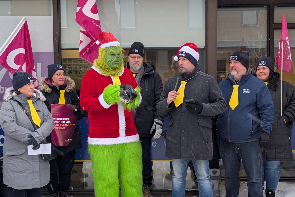 Grinch, coal, and yellow ties mark protest at Fedeli’s office about hospital service cuts