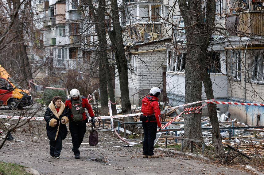 A member of emergency personnel assists an elderly woman who was inside an apartment building damaged by a Russian drone strike in Kyiv, Ukraine, on Tuesday.