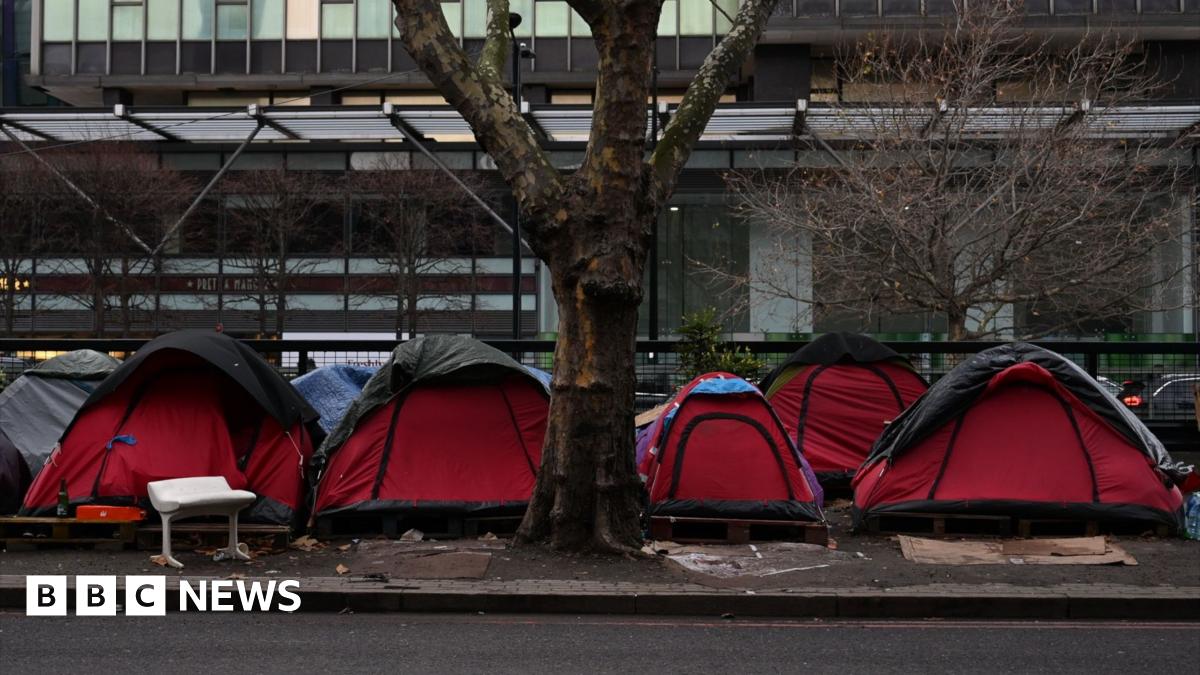 Red tents line a central London street beneath a bare tree.