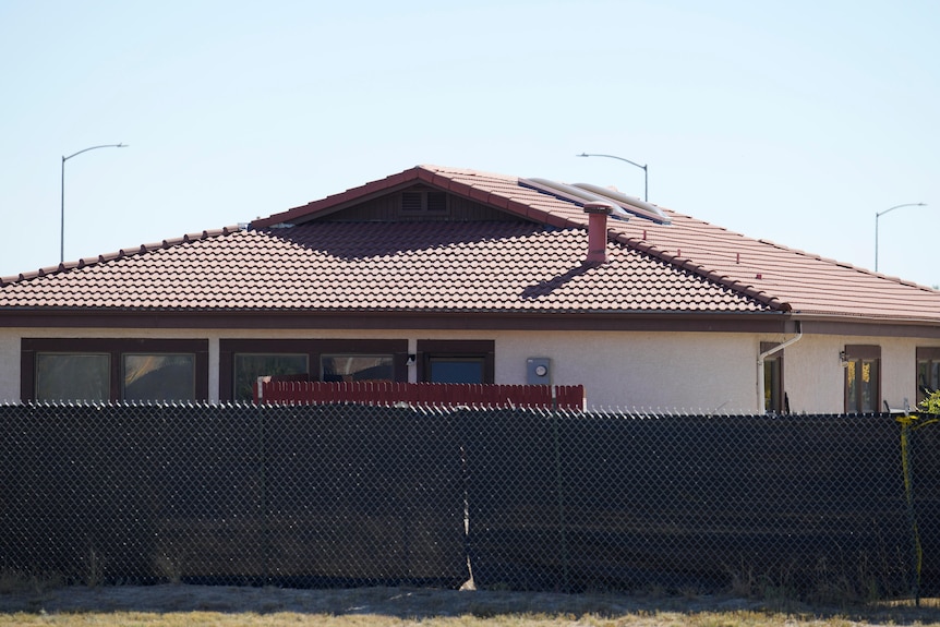 Black plastic fencing surrounding a building.
