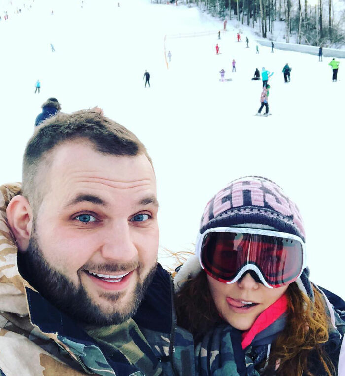 Man and woman wearing winter clothes and ski goggles on snowy slope, related to crypto scammer case details.