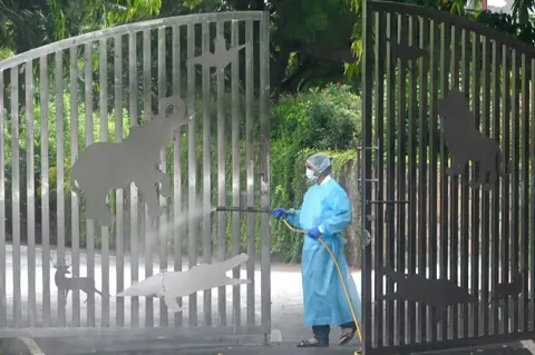 Hindustan Times via Getty Images A worker at National Zoological Park sprays pesticides at the entrance gate to sanitize the premises as bird flu spread in the zoo area on 1 September, 2025 in New Delhi, India. 