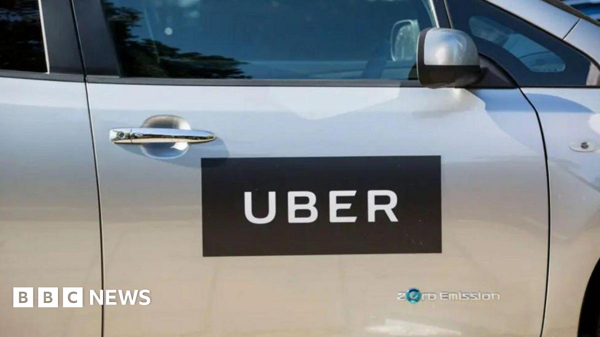 The outside of a silver vehicle with a black and white sign with the words "Uber" and "zero emission".