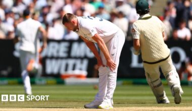 England bowler Gus Atkinson bends over to hold is legs with an apparent hamstring injury