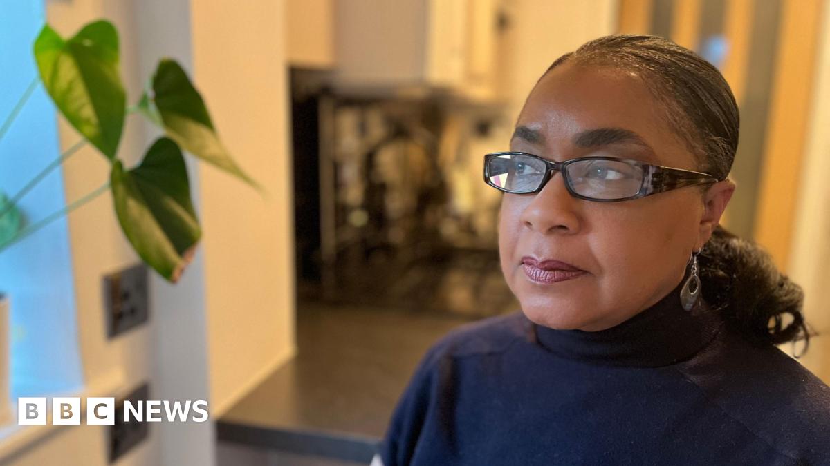 Denise has glasses on and looks out of the window